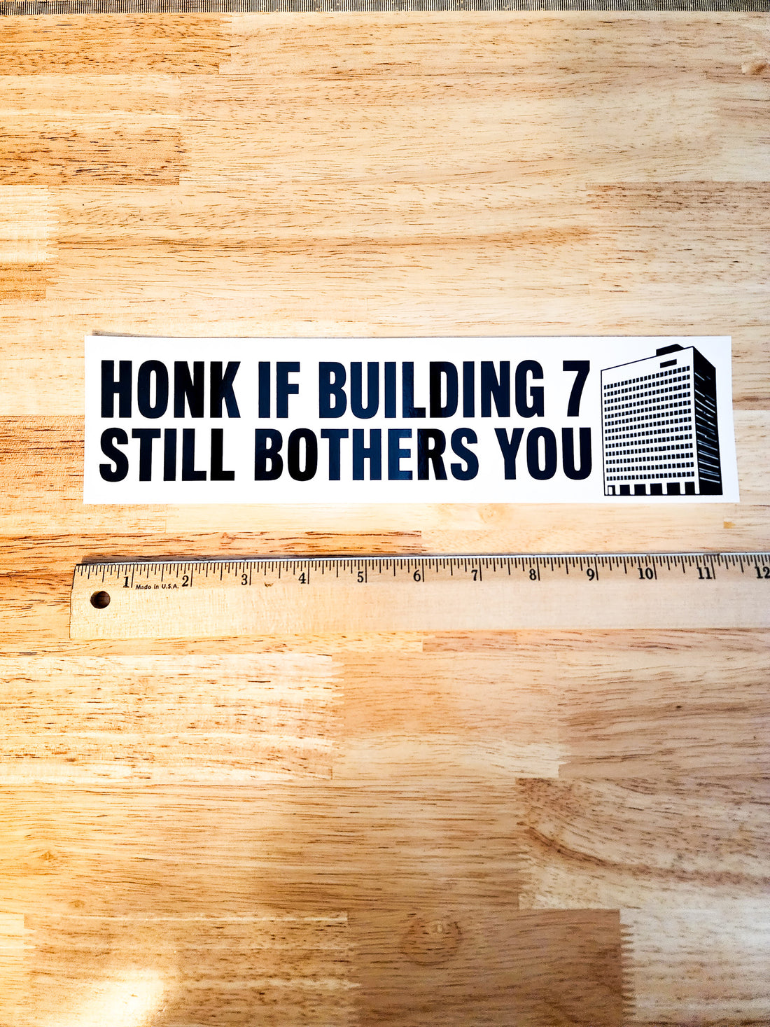 A rectangular bumper sticker with the text &